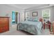 Comfortable bedroom featuring blue quilt, large windows, and ensuite bathroom at 1016 Luminary Ln, Willow Springs, NC 27592