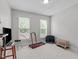 A bedroom with neutral-toned walls, two windows and a treadmill at 1016 Luminary Ln, Willow Springs, NC 27592