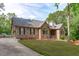 Well-maintained brick home with a lush green lawn, black shutters, and mature trees at 1016 Luminary Ln, Willow Springs, NC 27592
