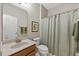 Well-lit bathroom featuring a vanity sink, toilet, and shower with a decorative curtain at 10520 Sablewood Dr # 103, Raleigh, NC 27617