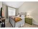 Bedroom with carpet, neutral walls, and a wrought-iron bed, complemented by a window view at 10520 Sablewood Dr # 103, Raleigh, NC 27617
