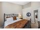 Bedroom featuring a wrought-iron bed, neutral walls, and carpet, complemented by a round mirror at 10520 Sablewood Dr # 103, Raleigh, NC 27617