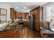Spacious kitchen with stainless steel appliances, granite counters, wooden cabinetry, and hardwood floors at 10520 Sablewood Dr # 103, Raleigh, NC 27617