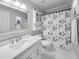 Bright bathroom featuring a patterned shower curtain, elegant vanity, and mirrored cabinet at 107 Long Shadow Ln, Cary, NC 27518