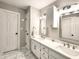 Bathroom featuring double sinks, pristine white cabinetry, framed mirrors, and marble flooring at 107 Long Shadow Ln, Cary, NC 27518
