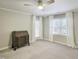 Well-lit bedroom with neutral walls and carpet, featuring an antique desk and sun-filled windows at 107 Long Shadow Ln, Cary, NC 27518
