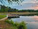 Picturesque lake with wooden docks, green trees, and a beautiful sunrise reflecting on the calm water at 107 Long Shadow Ln, Cary, NC 27518