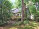 Exterior view of home's back deck surrounded by lush green trees and natural landscape at 107 Long Shadow Ln, Cary, NC 27518