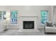 Cozy fireplace with white mantel, flanked by windows with views of the wooded property at 107 Long Shadow Ln, Cary, NC 27518
