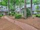 Well-maintained home exterior with a brick pathway lined with trees, connecting multiple units and enhancing curb appeal at 107 Long Shadow Ln, Cary, NC 27518