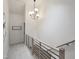Modern hallway with light wood and black metal railings, and unique pendant lighting at 107 Long Shadow Ln, Cary, NC 27518