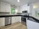 Bright kitchen with white cabinets, granite countertops, and stainless steel appliances at 107 Long Shadow Ln, Cary, NC 27518