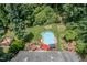 Aerial view of a backyard oasis with pool, hot tub, deck, garden, and lush greenery, offering private enjoyment at 108 Hanover Pl, Chapel Hill, NC 27516