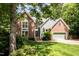 Beautiful two-story brick and siding home with an attached garage, surrounded by lush landscaping at 108 Hanover Pl, Chapel Hill, NC 27516