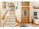 Bright foyer with wood trim, an elegant front door, and a staircase with carpeted steps at 108 Hanover Pl, Chapel Hill, NC 27516