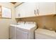 Functional laundry room with front-loading washer and dryer, ample storage, and utility sink at 108 Hanover Pl, Chapel Hill, NC 27516
