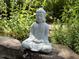 Close up of a Buddha statue surrounded by garden plants, sitting on a rock at 108 Hotelling Ct, Chapel Hill, NC 27514