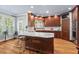 Well-equipped kitchen featuring wood cabinets, marble countertops, and views of lush greenery from bright windows at 108 Hotelling Ct, Chapel Hill, NC 27514