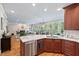 Open concept kitchen with wood cabinets, marble countertop island, stainless steel appliances, and seamless flow to the living room at 108 Hotelling Ct, Chapel Hill, NC 27514