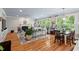 Open-concept living room featuring hardwood floors, fireplace, large windows, and dining area for seamless entertaining at 108 Hotelling Ct, Chapel Hill, NC 27514