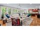 Cozy living room with a plush sectional sofa, oversized ottoman, and bright windows overlooking lush greenery at 108 Hotelling Ct, Chapel Hill, NC 27514