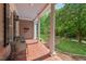 Inviting covered porch with brick floor, white columns, and views of the landscaped yard at 108 Hotelling Ct, Chapel Hill, NC 27514
