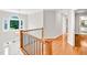 Upper hallway with gleaming hardwood floors, lots of natural light, and decorative railing at 110 Glenrose Ln, Cary, NC 27518