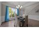 Bright dining room featuring dark wood flooring, white chair covers, decorative wall molding, and a chandelier at 110 Huntersville Rd, Morrisville, NC 27560