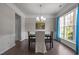 Cozy dining room with hardwood floors, decorative wall molding, and a bright window with blue curtains at 110 Huntersville Rd, Morrisville, NC 27560