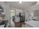Well-equipped kitchen featuring white cabinets, stainless steel appliances, stone countertops, and dark hardwood floors at 110 Huntersville Rd, Morrisville, NC 27560