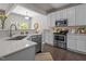Modern kitchen featuring white cabinets, stainless steel appliances, quartz countertops and dark wood flooring at 110 Huntersville Rd, Morrisville, NC 27560
