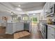 Open-concept kitchen with stainless steel appliances, white cabinets, and a view of the living area and backyard at 110 Huntersville Rd, Morrisville, NC 27560