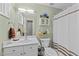 Bathroom with white vanity, decorative mirror, shower and a window at 11013 Louson Pl, Raleigh, NC 27614