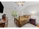 Cozy bedroom featuring a decorative bed frame, ceiling fan, and large window providing natural light at 11013 Louson Pl, Raleigh, NC 27614