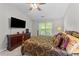 Bright bedroom featuring a decorative bed, ceiling fan, TV and window with a view at 11013 Louson Pl, Raleigh, NC 27614