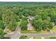 An aerial view of a home nestled among trees in a serene neighborhood, with the city skyline in the background at 1102 Laurens Way, Knightdale, NC 27545