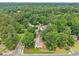 An aerial view of a home nestled among trees in a serene neighborhood, with the city skyline in the background at 1102 Laurens Way, Knightdale, NC 27545