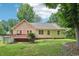 Back exterior featuring wooden deck, home siding, trimmed lawn and verdant plant life at 1102 Laurens Way, Knightdale, NC 27545