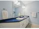 Light filled bathroom features dual sink vanity, large mirror and modern fixtures at 1102 Laurens Way, Knightdale, NC 27545