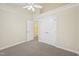 Bright bedroom featuring neutral carpet, ceiling fan, and closet with a bathroom doorway at 1102 Laurens Way, Knightdale, NC 27545
