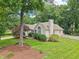 Exterior home shot with mature trees, manicured lawn, and white picket fence surrounding property at 1102 Laurens Way, Knightdale, NC 27545