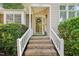 Inviting entryway featuring a wreath on the glass front door with brick stairs and white railing at 1102 Laurens Way, Knightdale, NC 27545