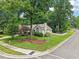 Charming one-story home featuring a manicured lawn, mature trees, and classic white picket fence at 1102 Laurens Way, Knightdale, NC 27545