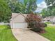 Exterior view showing garage, driveway and landscaping with mature trees on an overcast day at 1102 Laurens Way, Knightdale, NC 27545