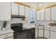 Bright kitchen features white cabinets, black appliances and tiled backsplash at 1102 Laurens Way, Knightdale, NC 27545