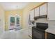 Bright kitchen with black appliances, yellow walls, white cabinets and outdoor access at 1102 Laurens Way, Knightdale, NC 27545