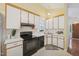 Bright kitchen features white cabinets, black appliances and tiled backsplash at 1102 Laurens Way, Knightdale, NC 27545