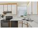 Bright kitchen features white cabinets, black appliances and tiled backsplash at 1102 Laurens Way, Knightdale, NC 27545