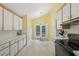 Bright kitchen with black appliances, yellow walls, white cabinets and outdoor access at 1102 Laurens Way, Knightdale, NC 27545