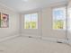 Bedroom with neutral carpet, two windows, and white trim at 111 Finsbury Street St, Durham, NC 27703
